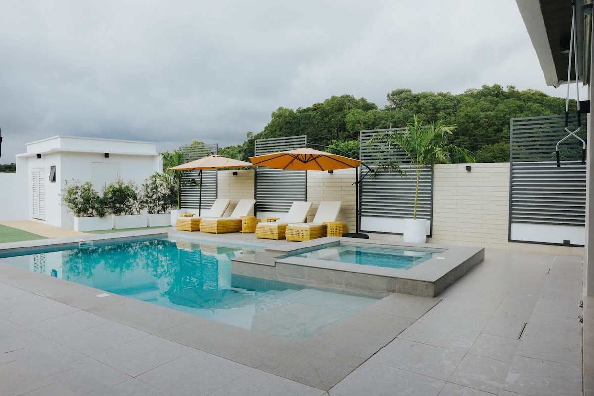 Private pool with jacuzzi, sun loungers, and orange umbrellas at The Sunhouse