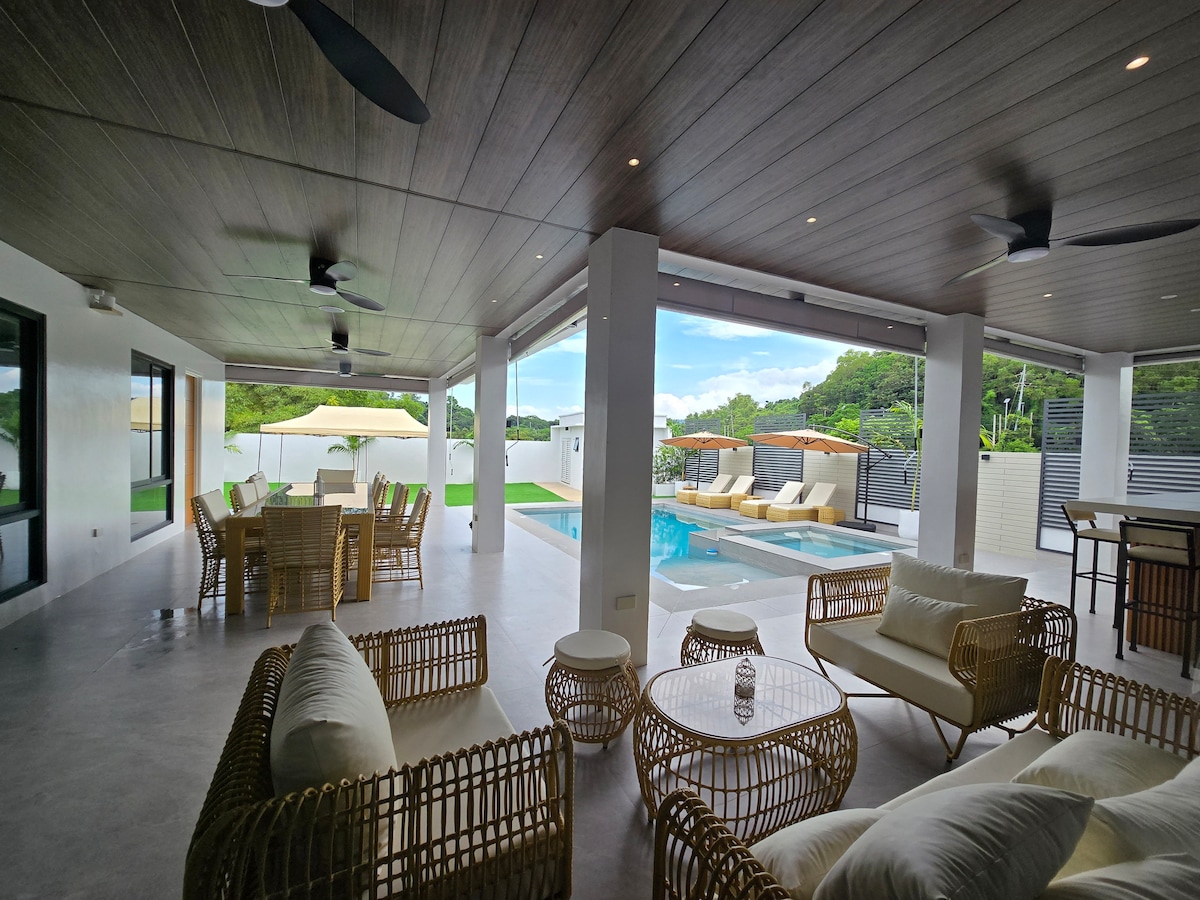 Covered patio with rattan lounge furniture overlooking pool