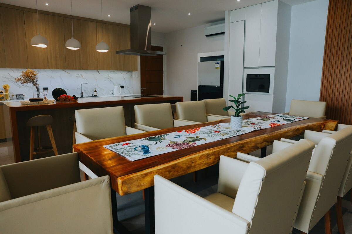 Gourmet kitchen with marble island and live-edge dining table